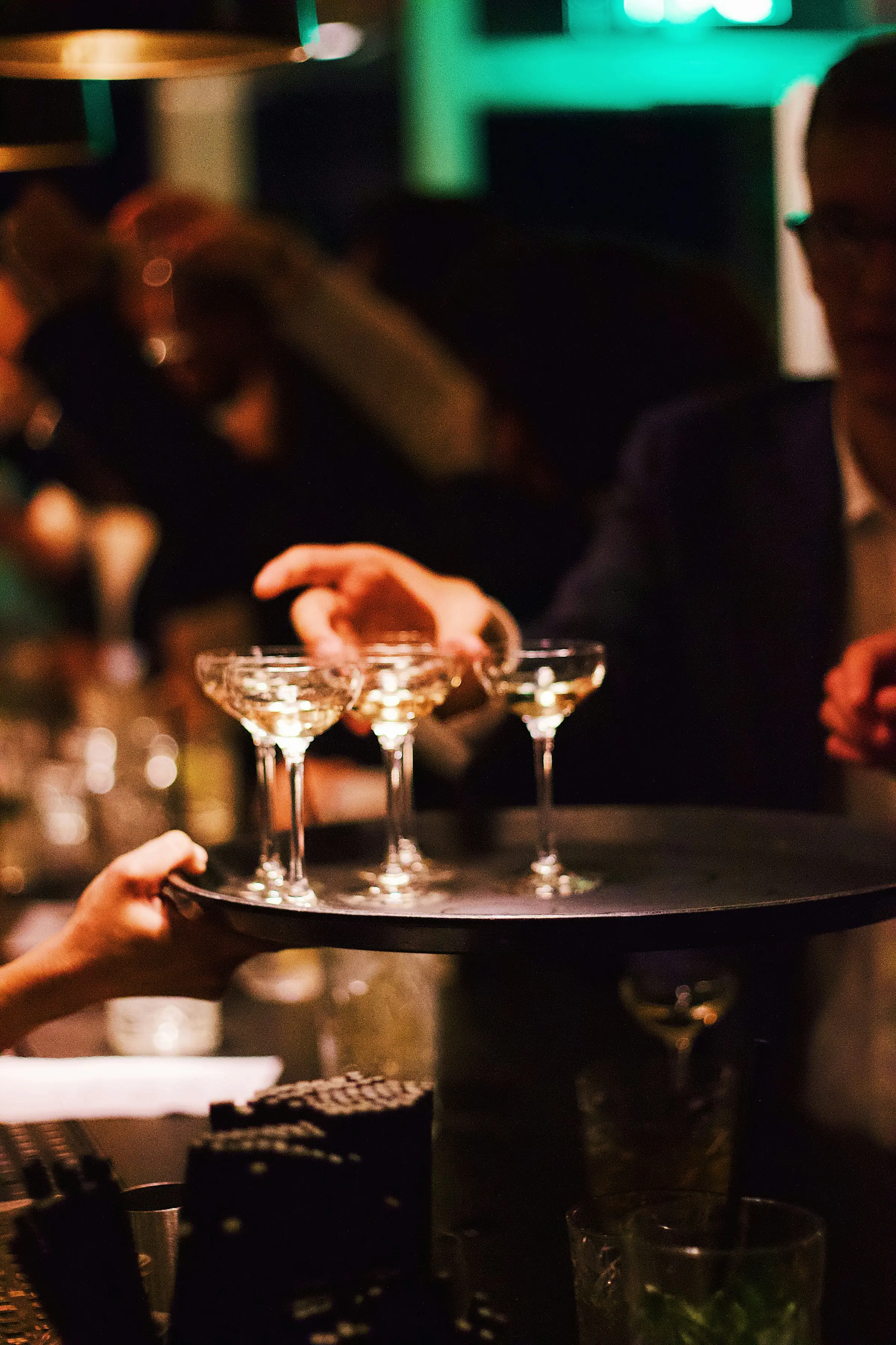 Plateau de coupes de champagne servi lors d’une soirée à l’éclairage tamisé